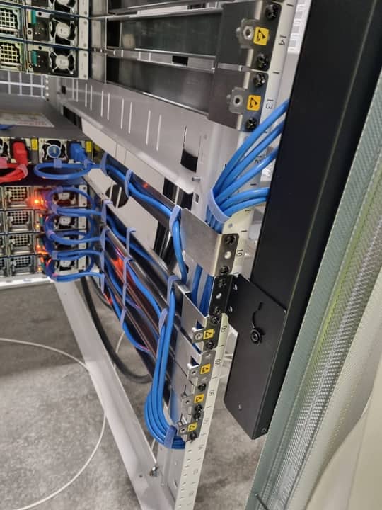 Blue Cat6 bundles dressed along a commercial rack rail